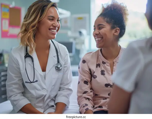 Two female doctors are talking and laughing with a patient.
