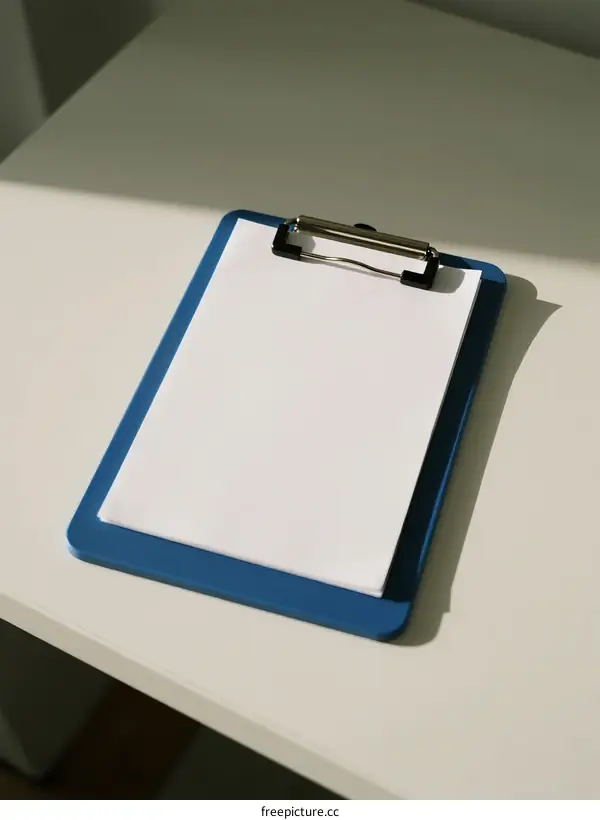 Blue Clipboard with White Paper on White Table Surface