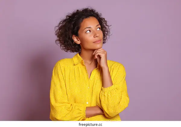Thoughtful Woman in Yellow Blouse against a Purple Background