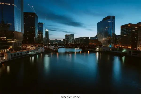 Cityscape at dusk with river flowing through modern buildings