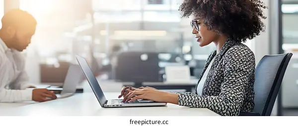 African American Woman Working on Laptop in Modern Office