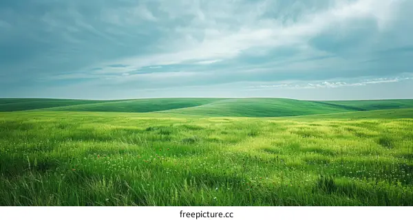 Green rolling hills under blue sky with clouds