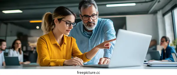 Two Business Professionals Working Together On Laptop