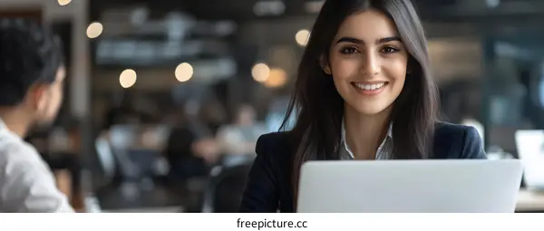 Smiling businesswoman working on a laptop in a cafe