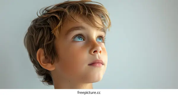 Portrait of a boy with freckles and blue eyes looking up