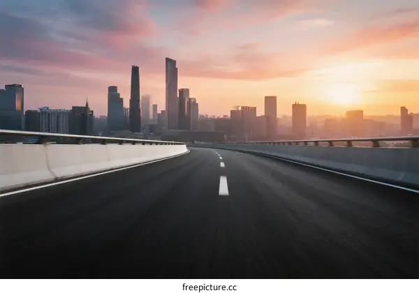 Sunset view of an empty highway leading into a modern city skyline