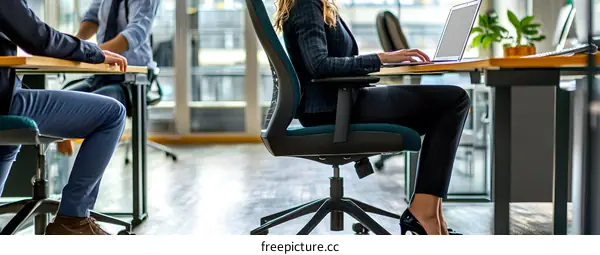 Modern Office Workspace with Employees Working on Laptops