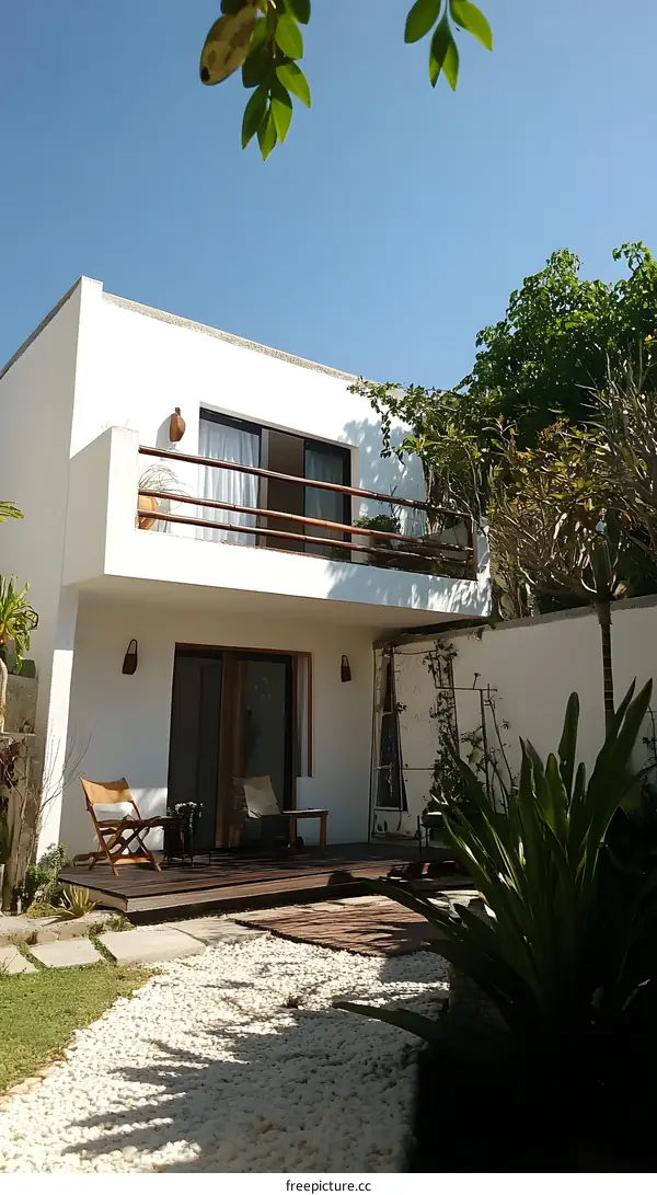 White Minimalist House with a Wooden Deck and White Gravel Garden