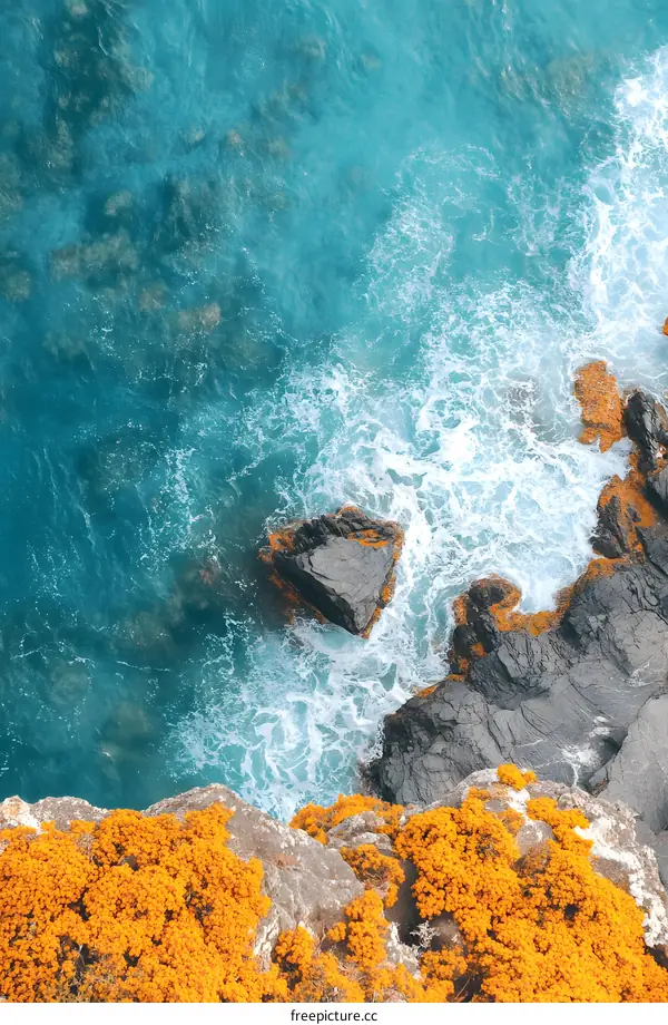 Aerial View of Ocean Waves Crashing Against Rocky Coastline