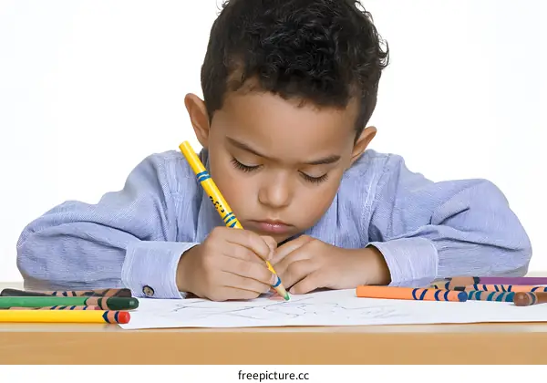 Young Boy Coloring with Crayons on White Paper