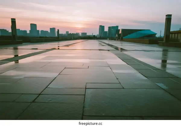 Sunset view of city square with wet pavement