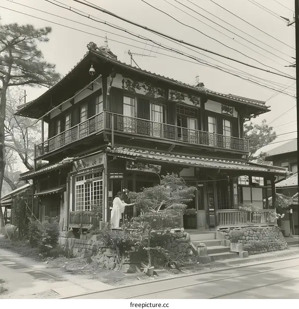 A traditional Japanese house with a person standing in front of it