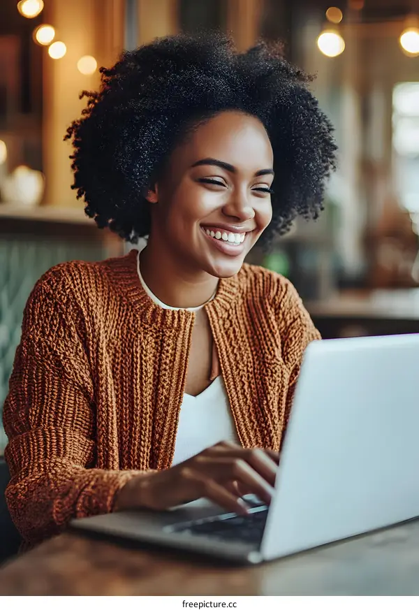 Smiling Woman Working on Laptop in Cafe