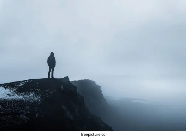 Man standing on a cliff looking out at the ocean