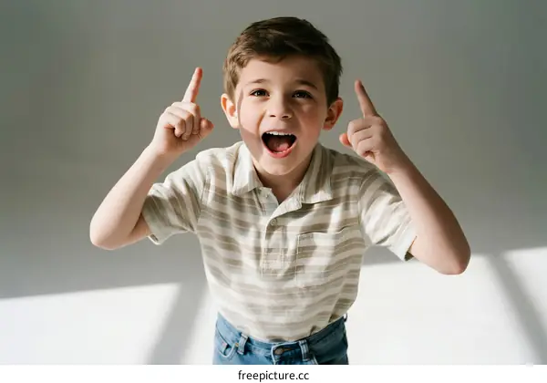 Young boy with excited expression pointing up with fingers