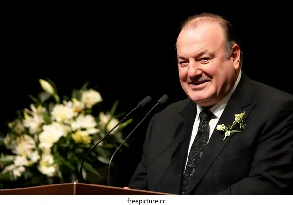 Man in Suit Speaking at a Podium with a Microphone