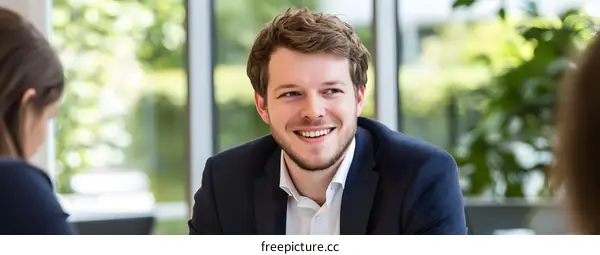 Smiling Man in Business Suit During Meeting