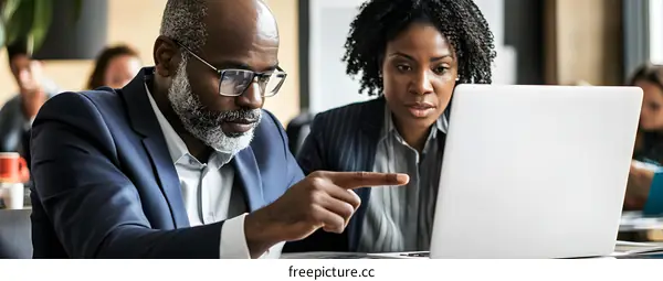 African American Businessman and Businesswoman Working Together on Laptop