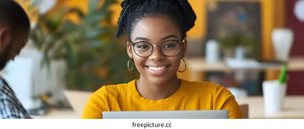 Smiling African American Woman Using Laptop In Modern Office