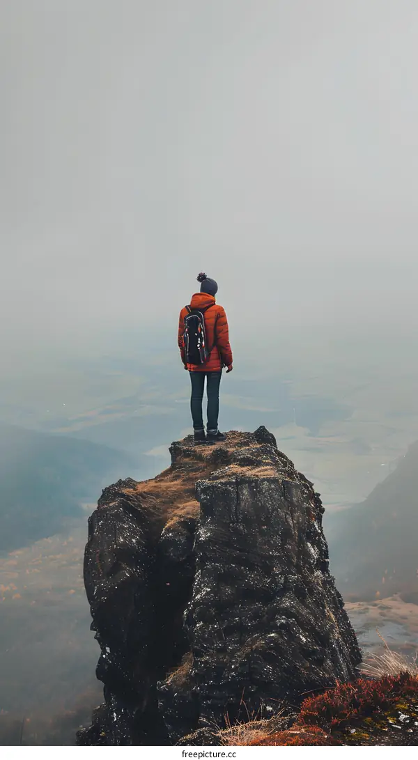 Solo Traveler Standing on a Mountain Cliff