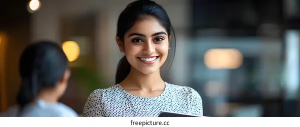 Smiling Indian Woman Holding Tablet In Office