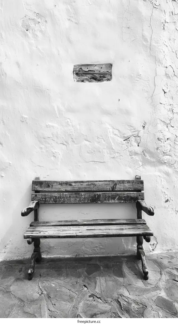 Wooden bench against a white wall