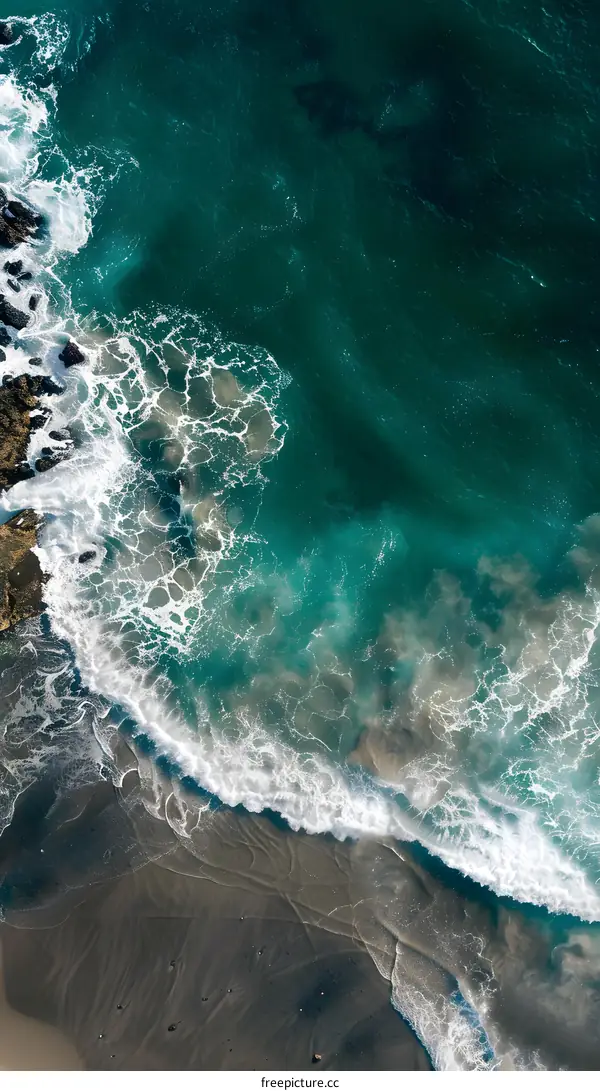 Aerial View of the Ocean Waves Crashing on the Sandy Beach