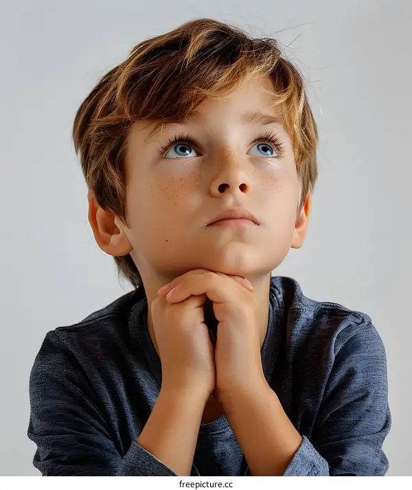 Young boy with blue eyes looking up hopefully