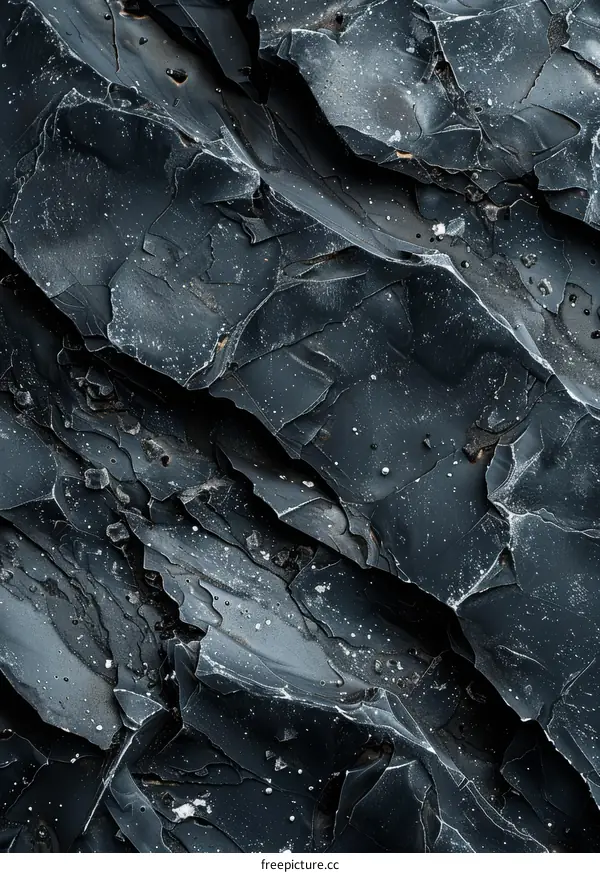 Black and grey rock surface with cracks and white spots