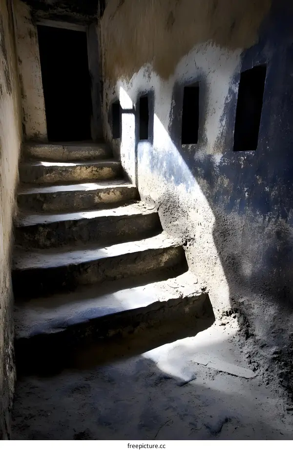 Stone Steps Leading Up to a Dark Room With Small Windows