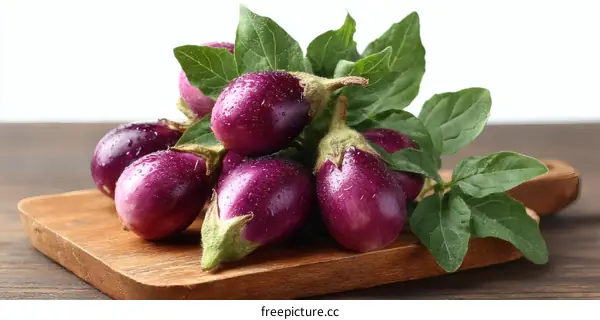 Fresh Purple Eggplants on Wooden Cutting Board