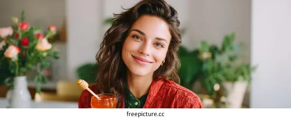 Smiling Woman Enjoying a Refreshing Drink in a Cozy Interior