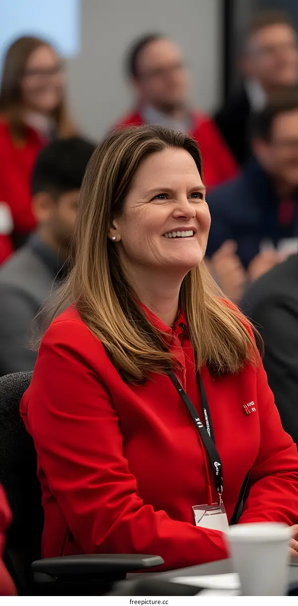 Smiling Woman in Red Jacket at a Conference