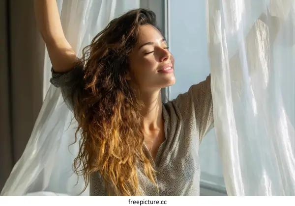 Woman enjoying the sunlight through the window