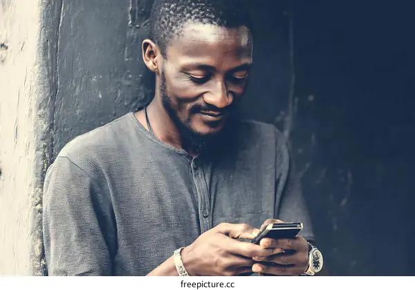 African Man Using Smartphone Outdoors