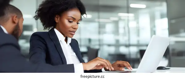 Two Business Professionals Working on a Laptop in an Office Setting