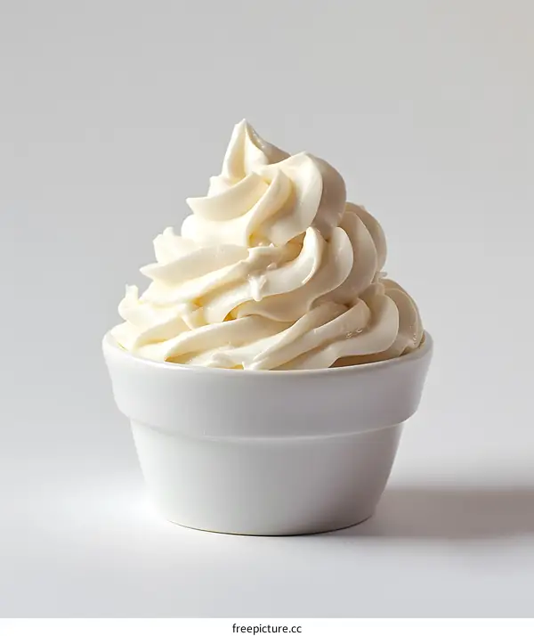 Bowl of whipped cream on white background