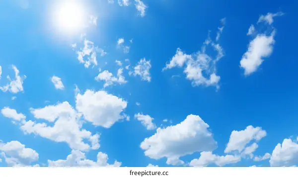 Blue sky with white clouds and bright sun