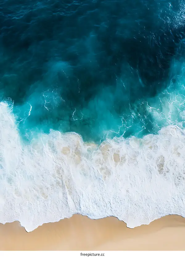 Aerial View of Ocean Waves Crashing on Sandy Beach