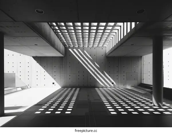 Light and shadow patterns on the floor through a geometric concrete ceiling