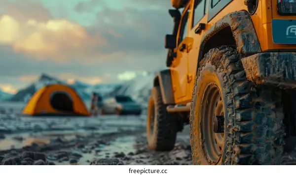 Muddy yellow Jeep with roof tent on snowy mountain landscape