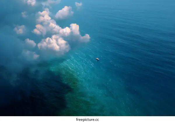 Aerial View of Clouds and Sea with Small Boat