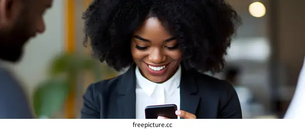African American Businesswoman Smiling While Using Smartphone
