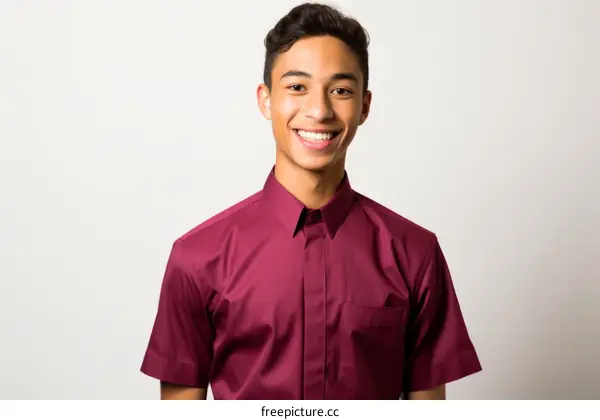 Portrait of a smiling young man in a maroon shirt
