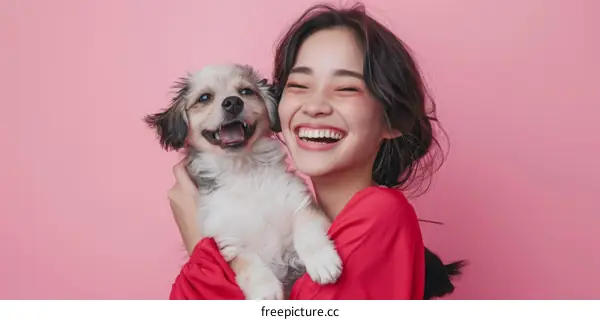 A young woman is smiling and hugging a small dog.