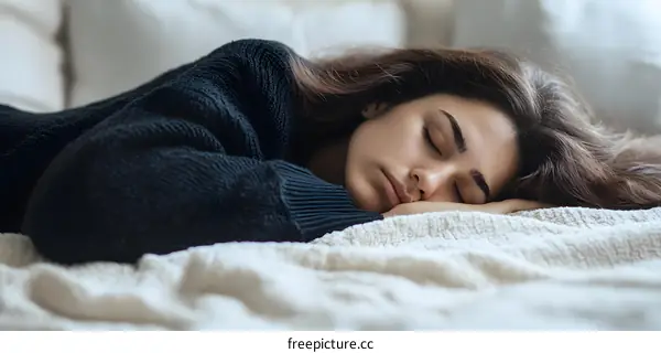 Young Woman Sleeping in Bed with Blanket