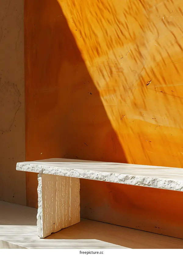 White Stone Bench Against a Yellow Wall with Light