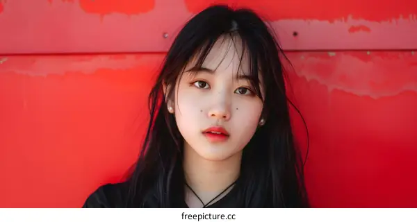 Portrait of a Young Asian Woman in Front of a Red Wall