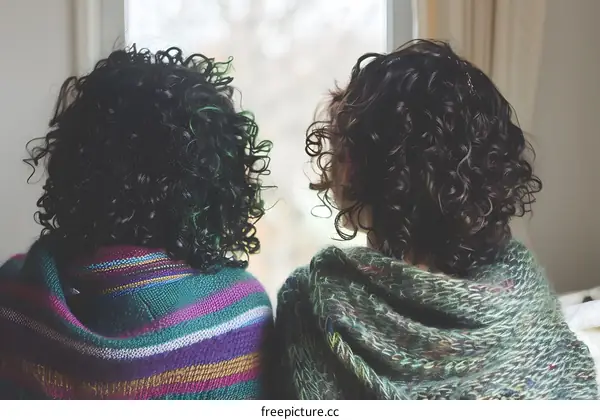 Two Women With Curly Hair Sitting by Window