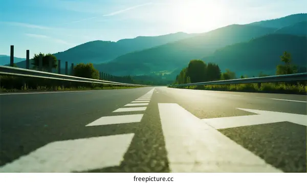 Sunlit road with mountainous landscape in the background